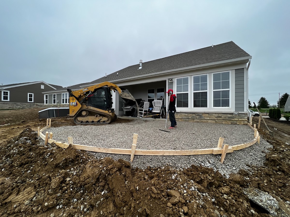 Skid steer and crew preparing a curved patio pour
