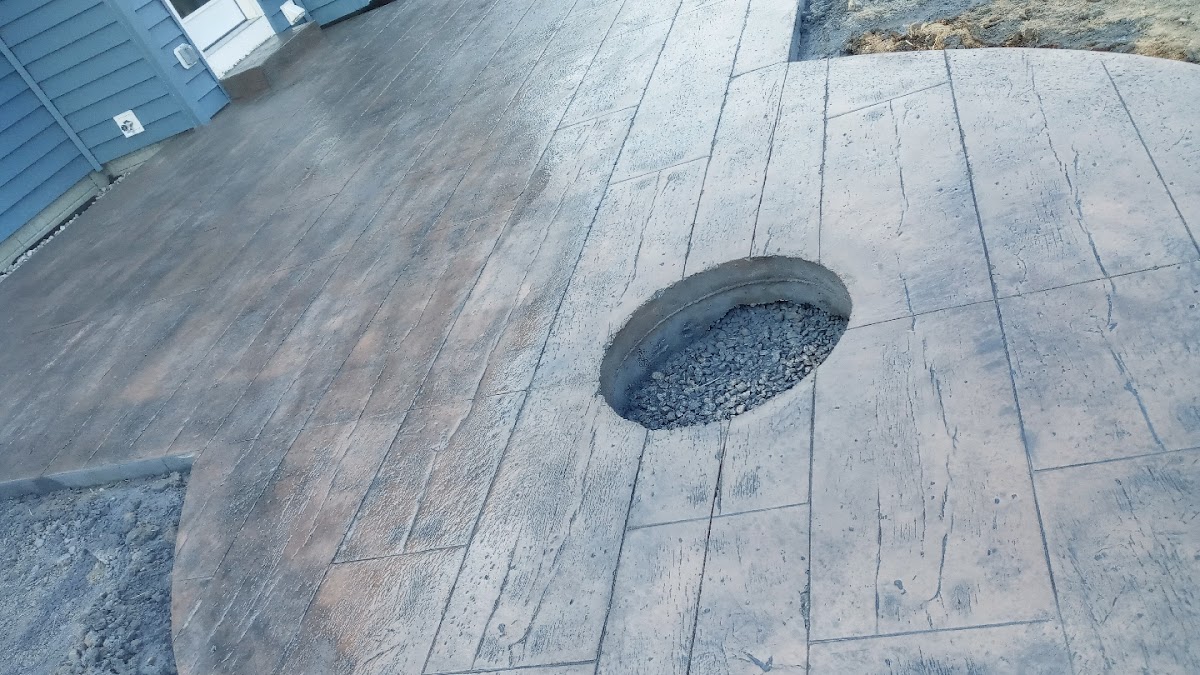 Wood-plank stamped concrete patio with a built-in fire pit